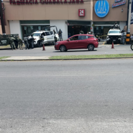 Elementos de seguridad resguardan el estacionamiento donde fue localizado un hombre sin vida en la avenida Plan de Ayala, en Cuernavaca.