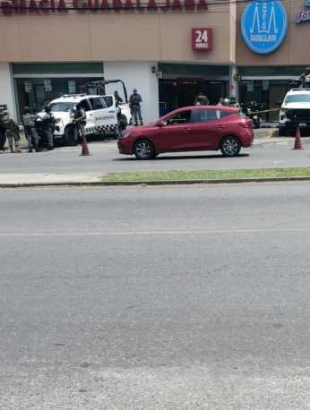 Elementos de seguridad resguardan el estacionamiento donde fue localizado un hombre sin vida en la avenida Plan de Ayala, en Cuernavaca.